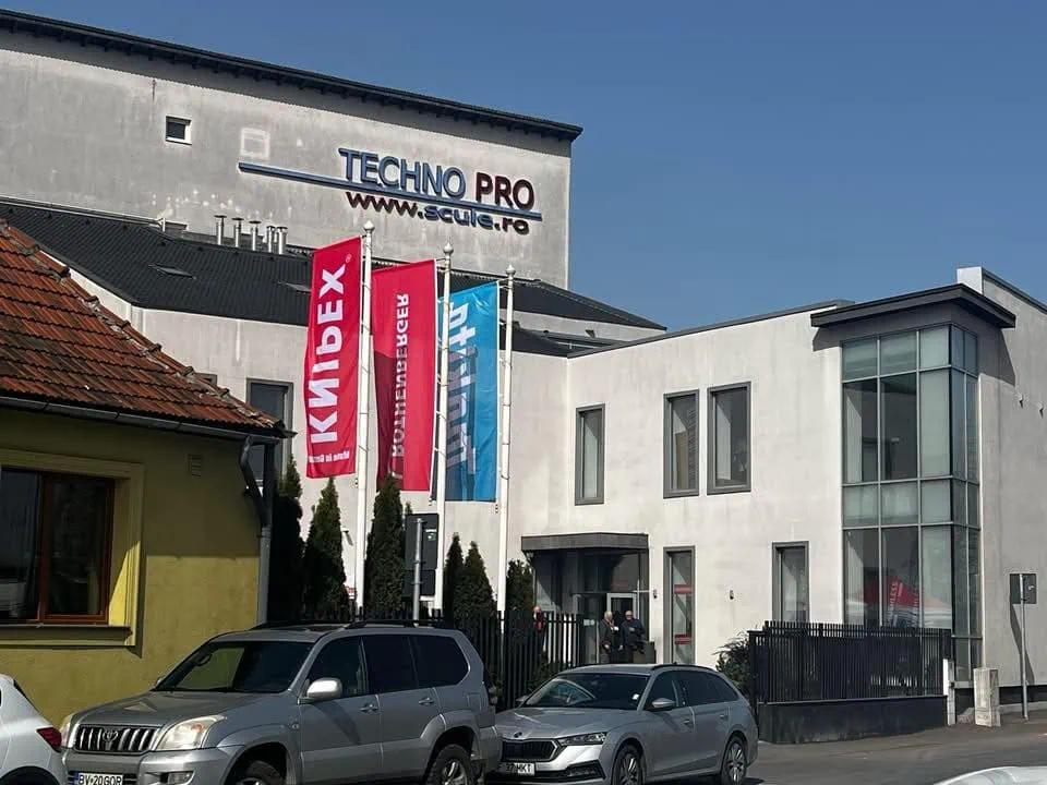 Clădire modernă cu steaguri colorate.